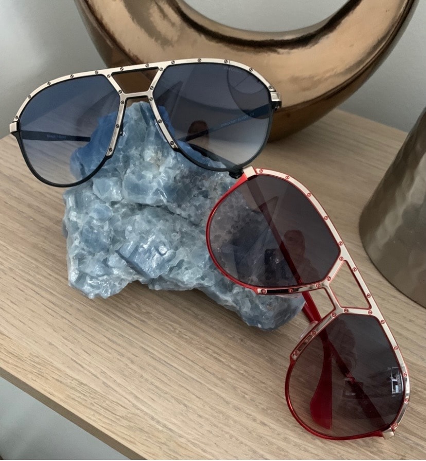 Two EYECON 87 Elvis 1 frames displayed on a crystal stand — black and red colorways